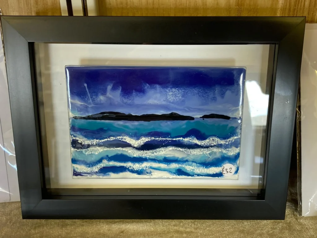 A wax painting of different shades of blue ocean
